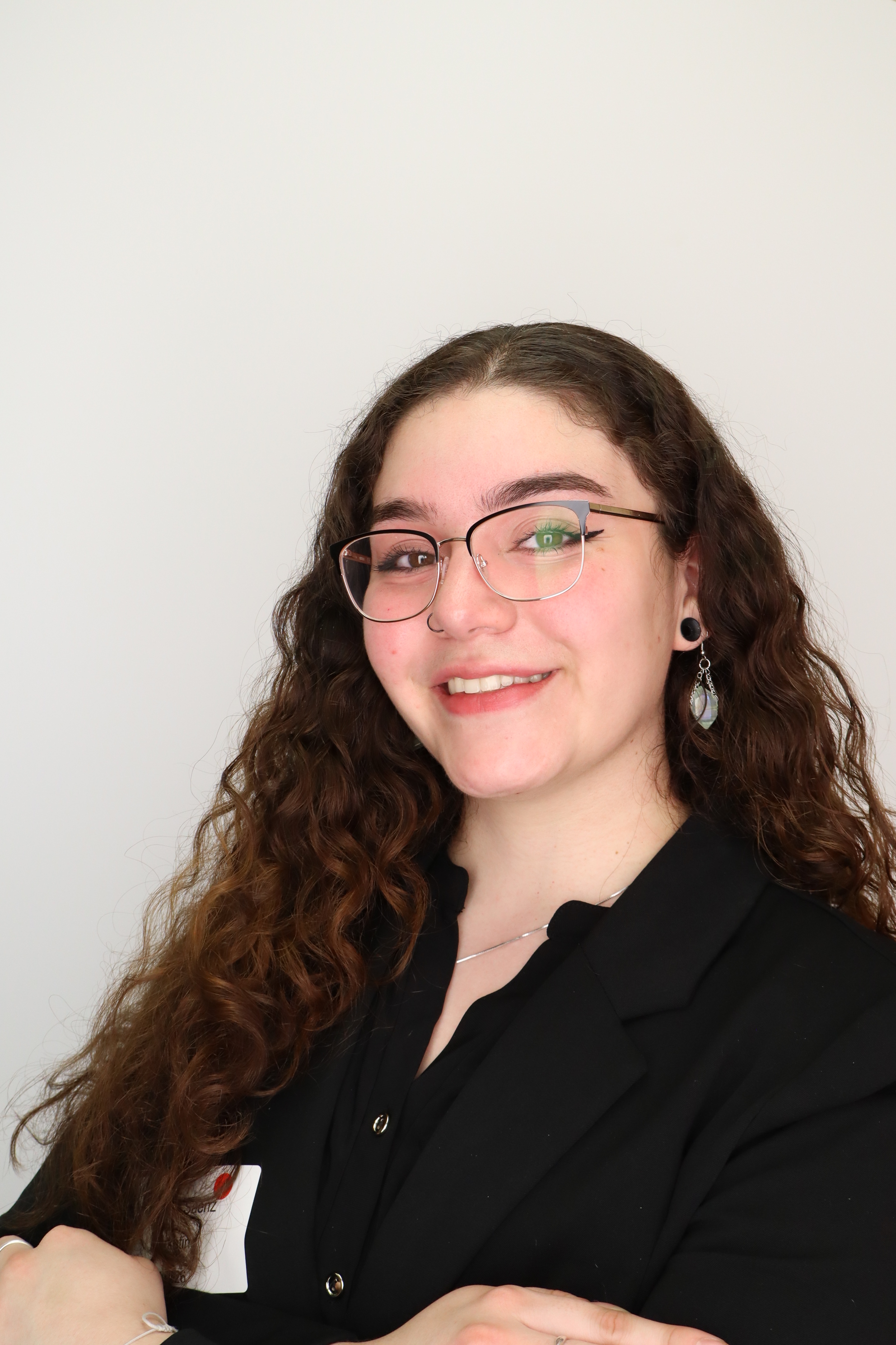 Brianna smiling in a black blazer.